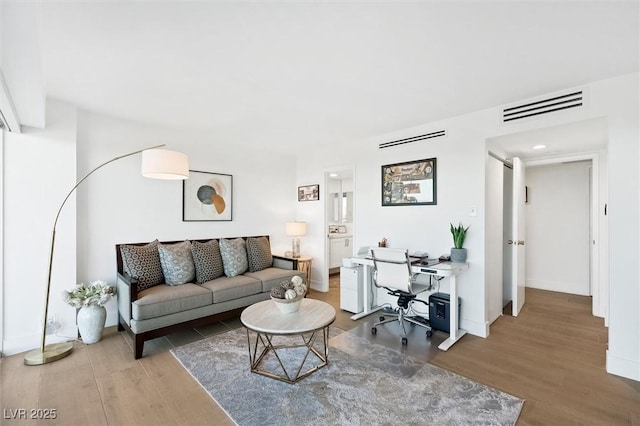 3111 Bel Air Dr Unit 7F, Las Vegas, NV 89109 - living room featuring wood finished floors, an office area, and baseboards