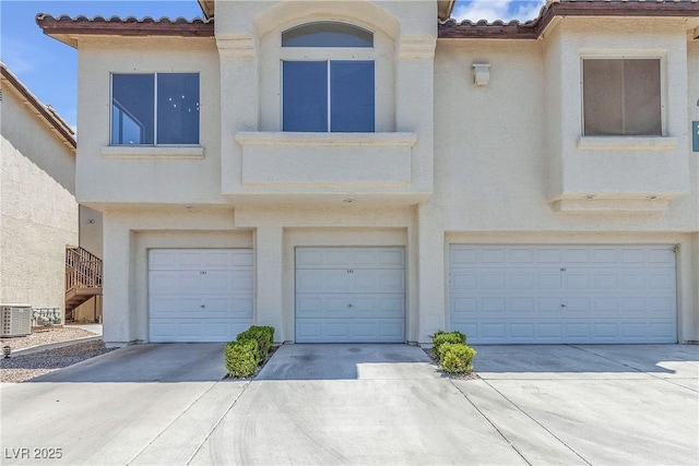 4800 Grey Wolf Ln Unit 202, Las Vegas, NV 89149 - view of property with a tiled roof, a garage, stucco siding, and driveway