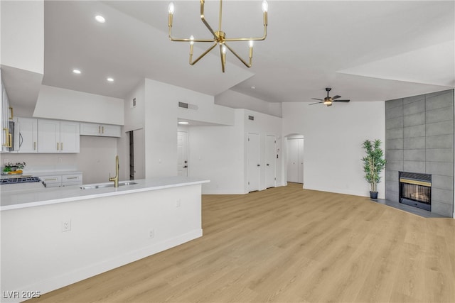 4800 Grey Wolf Ln Unit 202, Las Vegas, NV 89149 - unfurnished living room with recessed lighting, light wood-style floors, a fireplace, a ceiling fan, and arched walkways