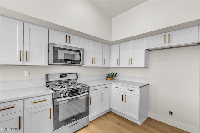 4800 Grey Wolf Ln Unit 202, Las Vegas, NV 89149 - kitchen with stainless steel appliances, light wood finished floors, and white cabinetry