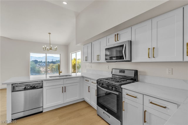 4800 Grey Wolf Ln Unit 202, Las Vegas, NV 89149 - kitchen featuring stainless steel appliances, a sink, a chandelier, a peninsula, and white cabinetry