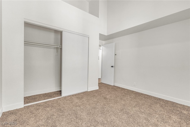 4800 Grey Wolf Ln Unit 202, Las Vegas, NV 89149 - unfurnished bedroom featuring carpet, a closet, and a towering ceiling