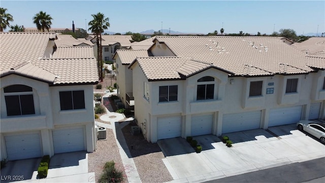 4800 Grey Wolf Ln Unit 202, Las Vegas, NV 89149 - view of front of property featuring a tiled roof, a garage, stucco siding, and driveway