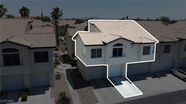 4800 Grey Wolf Ln Unit 202, Las Vegas, NV 89149 - view of front of home with a garage, a tiled roof, driveway, stucco siding, and a residential view