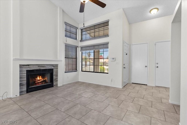 6997 Ray Charles Ln, Las Vegas, NV 89119 - unfurnished living room featuring high vaulted ceiling, ceiling fan, a tile fireplace, a textured ceiling, and tile patterned floors