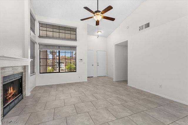 6997 Ray Charles Ln, Las Vegas, NV 89119 - unfurnished living room with a ceiling fan, high vaulted ceiling, a tile fireplace, baseboards, and tile patterned flooring