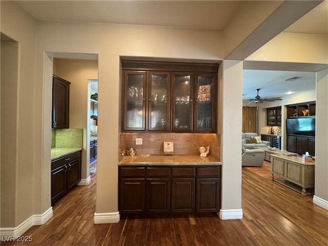 4208 Agosta Luna Pl, Las Vegas, NV 89135 - bar area featuring decorative backsplash, dark wood-style floors, baseboards, and wall oven