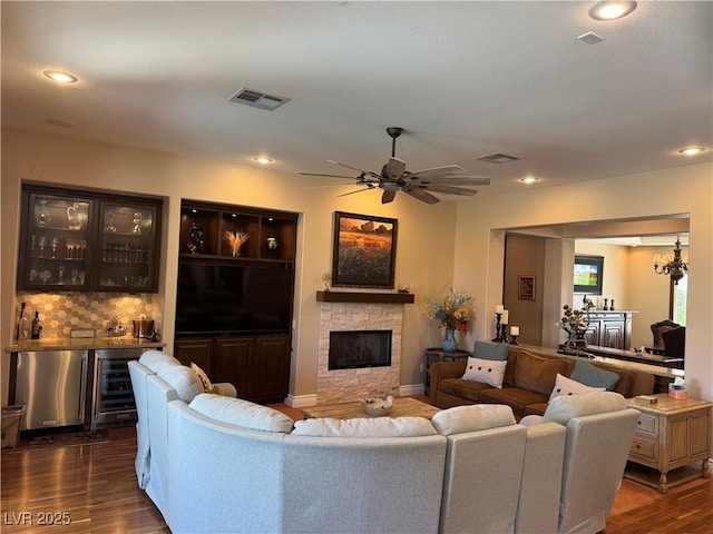 4208 Agosta Luna Pl, Las Vegas, NV 89135 - living area with wet bar, dark wood finished floors, a stone fireplace, beverage cooler, and recessed lighting