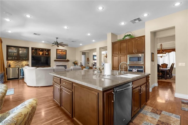 4208 Agosta Luna Pl, Las Vegas, NV 89135 - kitchen featuring appliances with stainless steel finishes, a sink, light wood-style floors, ceiling fan, and a kitchen island with sink