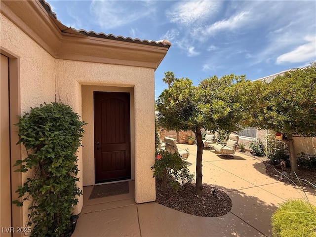 4208 Agosta Luna Pl, Las Vegas, NV 89135 - property entrance featuring a patio, stucco siding, and a tiled roof