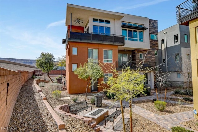 10985 Limeslice Ave Unit 2, Las Vegas, NV 89135 - rear view of property featuring a balcony, stucco siding, and an outdoor fire pit