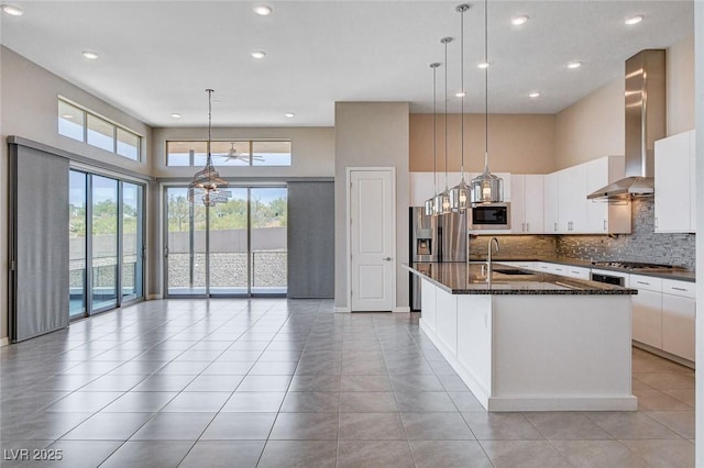 10985 Limeslice Ave Unit 2, Las Vegas, NV 89135 - kitchen featuring stainless steel appliances, wall chimney exhaust hood, decorative backsplash, recessed lighting, and white cabinetry