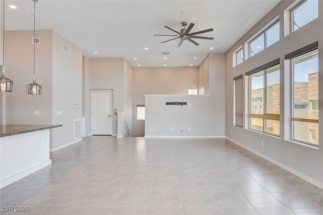 10985 Limeslice Ave Unit 2, Las Vegas, NV 89135 - unfurnished living room with ceiling fan, a towering ceiling, light tile patterned floors, and recessed lighting