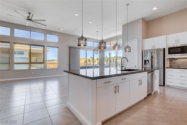 10985 Limeslice Ave Unit 2, Las Vegas, NV 89135 - kitchen with stainless steel appliances, a ceiling fan, a center island with sink, light tile patterned floors, and recessed lighting