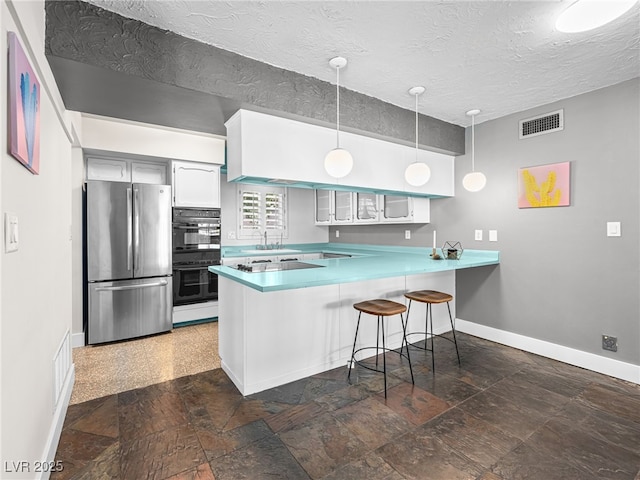 3212 Silver Saddle St, Las Vegas, NV 89169 - kitchen featuring freestanding refrigerator, a peninsula, baseboards, a breakfast bar area, and stone tile flooring