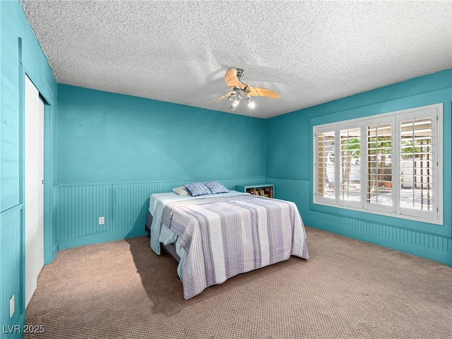 3212 Silver Saddle St, Las Vegas, NV 89169 - carpeted bedroom with wainscoting, ceiling fan, and a textured ceiling