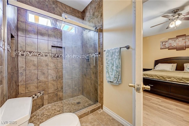 9370 Corkfish St, Las Vegas, NV 89178 - ensuite bathroom with toilet, a stall shower, a ceiling fan, baseboards, and tile patterned floors