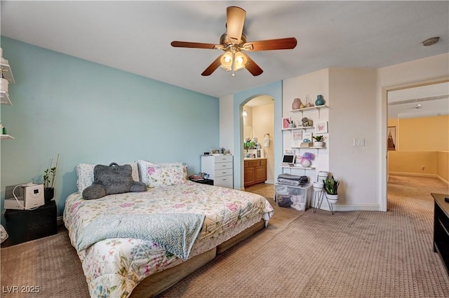 9370 Corkfish St, Las Vegas, NV 89178 - bedroom with arched walkways, light colored carpet, a ceiling fan, baseboards, and ensuite bathroom