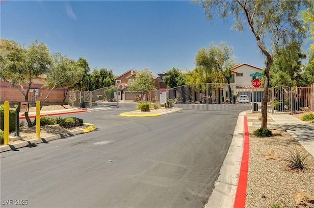 9370 Corkfish St, Las Vegas, NV 89178 - view of asphalt street featuring sidewalks, a gate, curbs, a gated entry, and traffic signs