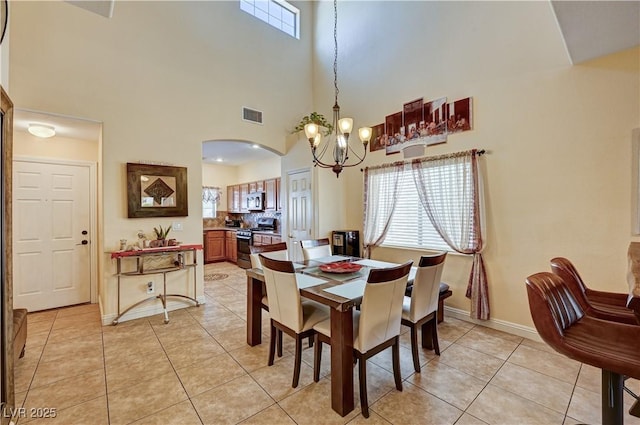 9370 Corkfish St, Las Vegas, NV 89178 - dining space with a chandelier, light tile patterned floors, arched walkways, a high ceiling, and baseboards