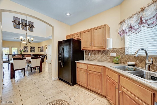 9370 Corkfish St, Las Vegas, NV 89178 - kitchen featuring black fridge with ice dispenser, a sink, a chandelier, light tile patterned flooring, and tasteful backsplash