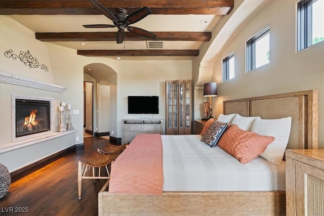 20 Via Paradiso St, Henderson, NV 89011 - bedroom featuring wood finished floors, arched walkways, a glass covered fireplace, beam ceiling, and baseboards