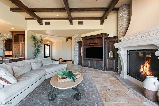 20 Via Paradiso St, Henderson, NV 89011 - living area featuring a warm lit fireplace, stone tile floors, beam ceiling, coffered ceiling, and baseboards