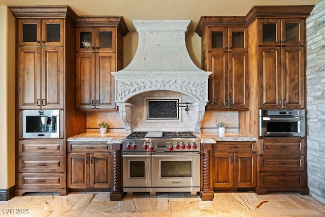20 Via Paradiso St, Henderson, NV 89011 - kitchen with stainless steel appliances, premium range hood, light stone countertops, and backsplash