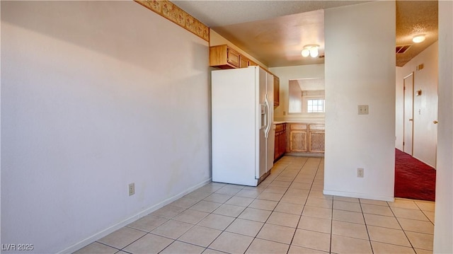 305 Crosswind Way, Las Vegas, NV 89145 - kitchen with white fridge with ice dispenser, light tile patterned flooring, baseboards, and light countertops