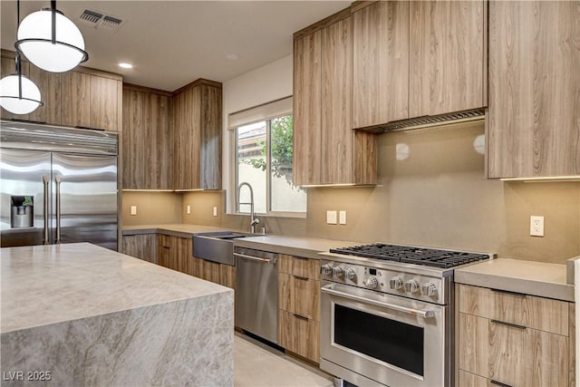 9921 Mirada Dr, Las Vegas, NV 89144 - kitchen featuring high end appliances, modern cabinets, light countertops, light brown cabinetry, and recessed lighting