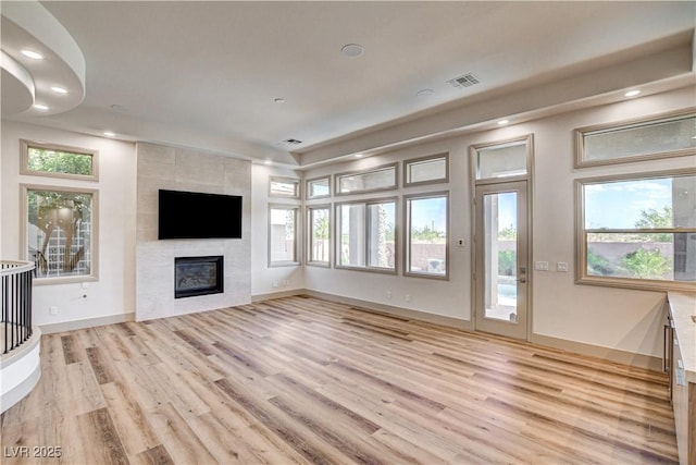 9921 Mirada Dr, Las Vegas, NV 89144 - unfurnished living room featuring light wood-style floors, a tile fireplace, recessed lighting, healthy amount of natural light, and baseboards
