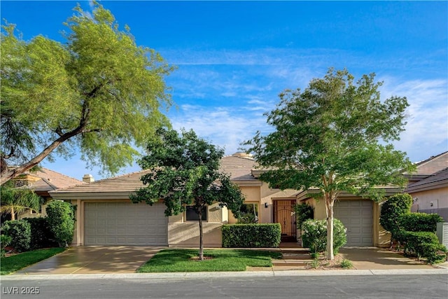 9921 Mirada Dr, Las Vegas, NV 89144 - view of property hidden behind natural elements with stucco siding, an attached garage, and driveway
