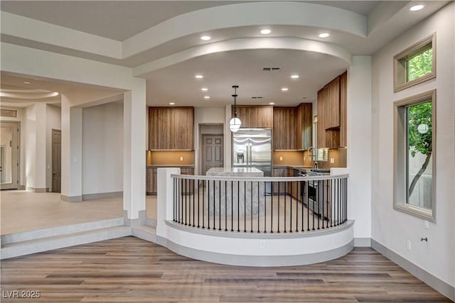 9921 Mirada Dr, Las Vegas, NV 89144 - kitchen featuring stainless steel built in fridge, brown cabinets, wood finished floors, a peninsula, and recessed lighting