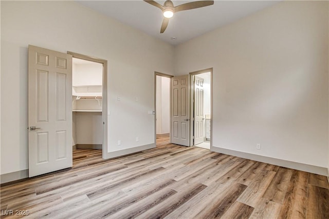 9921 Mirada Dr, Las Vegas, NV 89144 - unfurnished bedroom with light wood-type flooring, a walk in closet, a closet, ensuite bath, and ceiling fan