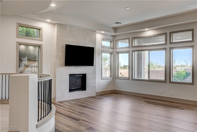 9921 Mirada Dr, Las Vegas, NV 89144 - unfurnished living room with wood finished floors, a tiled fireplace, and recessed lighting