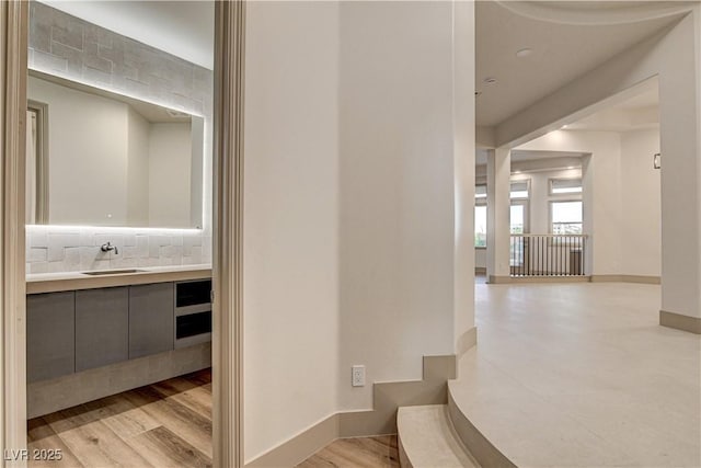 9921 Mirada Dr, Las Vegas, NV 89144 - hall featuring a sink, baseboards, and light wood-style floors