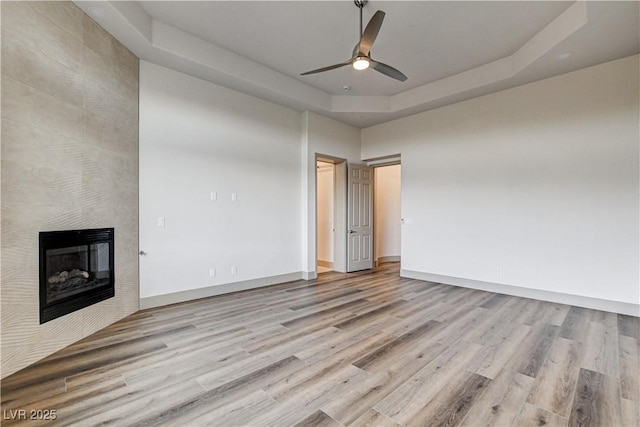 9921 Mirada Dr, Las Vegas, NV 89144 - unfurnished living room with wood finished floors, ceiling fan, a fireplace, and baseboards