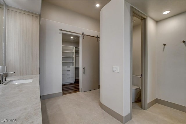 9921 Mirada Dr, Las Vegas, NV 89144 - bathroom with double vanity, toilet, a spacious closet, baseboards, and recessed lighting