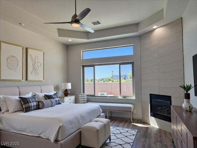 9921 Mirada Dr, Las Vegas, NV 89144 - bedroom with wood finished floors, recessed lighting, a ceiling fan, and a tile fireplace