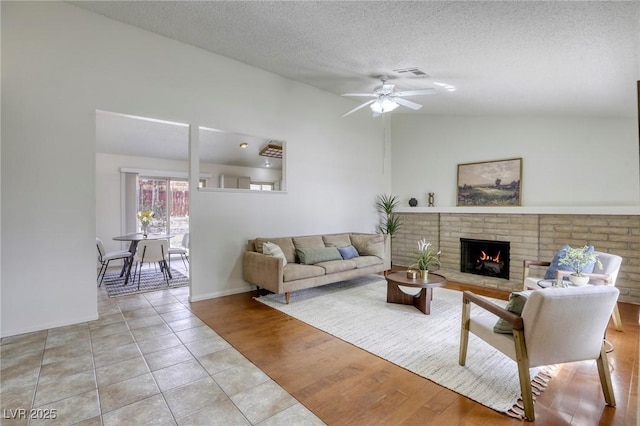 1012 Winwood St, Las Vegas, NV 89108 - living area featuring lofted ceiling, a fireplace, a ceiling fan, a textured ceiling, and light tile patterned floors
