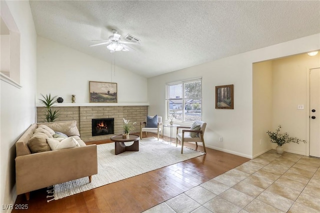 1012 Winwood St, Las Vegas, NV 89108 - living room with a ceiling fan, a textured ceiling, vaulted ceiling, a brick fireplace, and wood finished floors