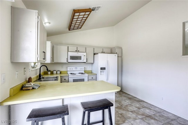 1012 Winwood St, Las Vegas, NV 89108 - kitchen with white appliances, a sink, a peninsula, vaulted ceiling, and light countertops