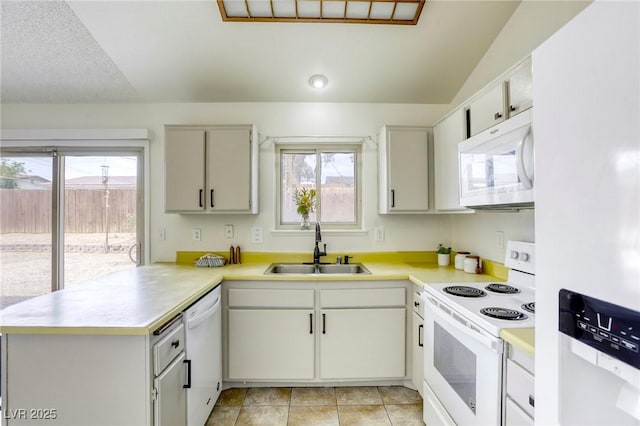 1012 Winwood St, Las Vegas, NV 89108 - kitchen with white appliances, a sink, a peninsula, light countertops, and light tile patterned floors