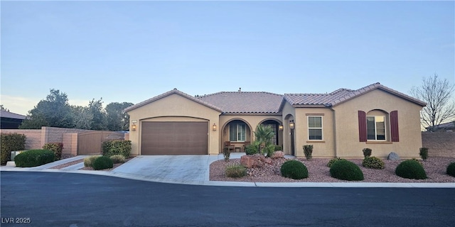 4242 Helena Hideaway Ct, Las Vegas, NV 89129 - mediterranean / spanish-style home featuring stucco siding, a tiled roof, an attached garage, and concrete driveway