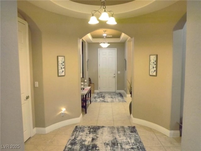 4242 Helena Hideaway Ct, Las Vegas, NV 89129 - corridor featuring a raised ceiling, arched walkways, light tile patterned floors, baseboards, and a chandelier