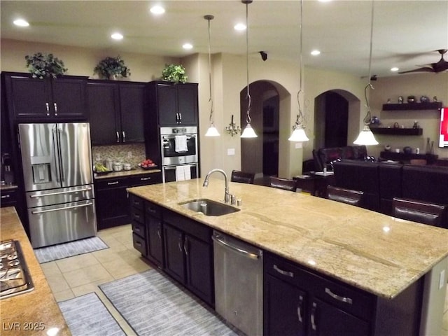 4242 Helena Hideaway Ct, Las Vegas, NV 89129 - kitchen with appliances with stainless steel finishes, a sink, arched walkways, open floor plan, and light tile patterned floors