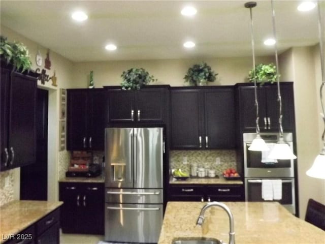 4242 Helena Hideaway Ct, Las Vegas, NV 89129 - kitchen featuring stainless steel appliances, a sink, recessed lighting, tasteful backsplash, and light stone countertops