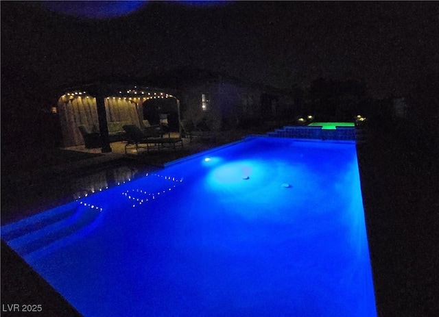 4242 Helena Hideaway Ct, Las Vegas, NV 89129 - pool at night featuring an outdoor pool and a patio