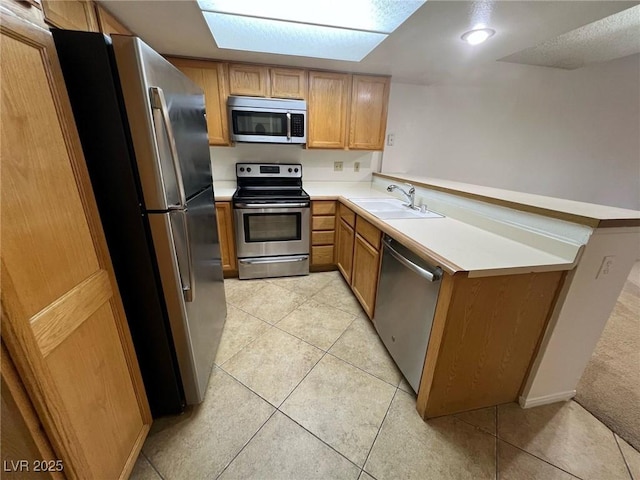 8940 Antioch Way, Las Vegas, NV 89117 - kitchen with stainless steel appliances, a sink, a peninsula, light countertops, and light tile patterned floors