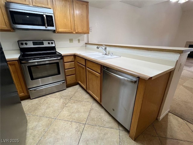 8940 Antioch Way, Las Vegas, NV 89117 - kitchen with appliances with stainless steel finishes, a peninsula, a sink, light countertops, and light tile patterned floors